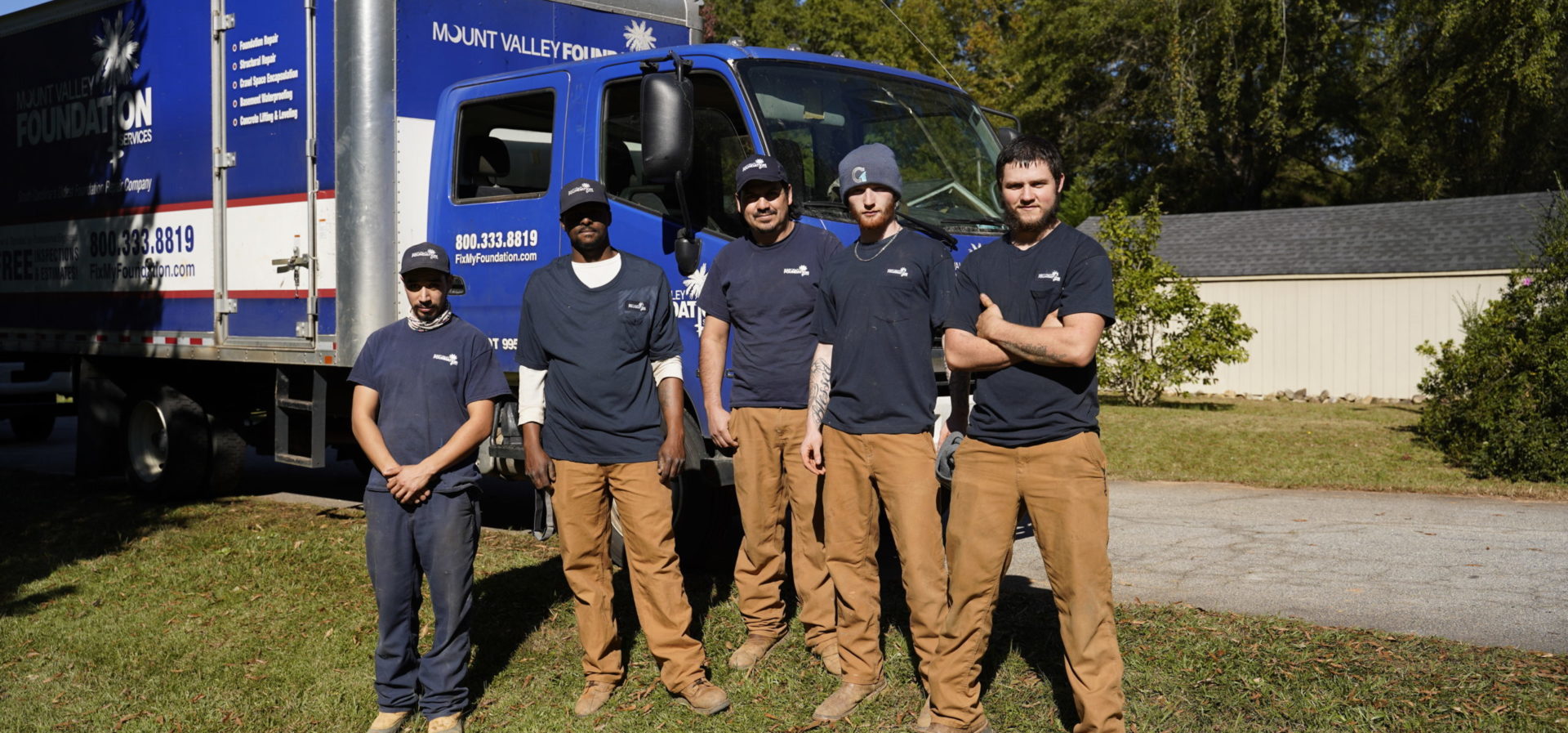 Crew outside of residential in front of supply truck.